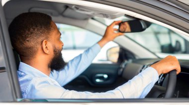 Genç Siyah Adam Yeni Araç Seçiyor, Arabanın İçinde Oturuyor ve Dikiz Aynasını Ayarlıyor, Mutlu Afrikalı Amerikalı Erkek Müşteri Satın Alma Otomobili Modern Satış Merkezi, Yakın Çekim