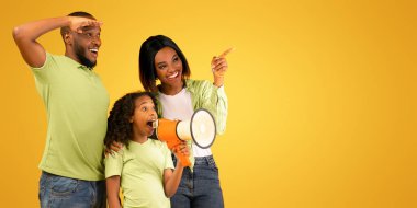 Üç kişilik mutlu Afro-Amerikan ailesi anons yapıyor, hoparlörde konuşan ve sarı arkaplanda fotokopi odasına bakan kız, panorama, stüdyo çekimi.