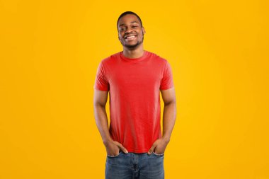 Sarı Stüdyo 'nun arka planında el ele tutuşan yakışıklı Afro-Amerikalı genç adam. Neşeli Siyah Adam Olumlu Duyguları İfade Eden Kameraya Gülümsüyor