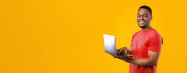 Serbest meslek hayatı. Sarı Arkaplan 'ın üstünde duran Stüdyo Çekimi' ne gülümseyen dizüstü bilgisayar kullanan mutlu siyah adam. İnsan ve Gadget 'lar, E-Öğrenme ve İnternet Teknolojileri Konsepti