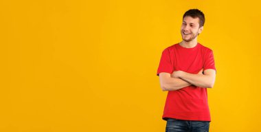 Yakışıklı sakallı adamın portresi gülümsüyor ve mavi stüdyo arka planında izole edilmiş fotokopi alanına bakıyor. Mutlu beyaz adam mutlu yüz ifadesiyle kollarını kavuşturmuş poz veriyor.