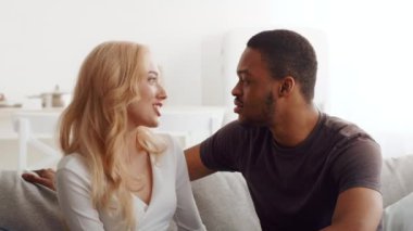 Çift ırklı bir çift kanepede yan yana oturur, birbirlerine gülümseyerek ve samimiyetle bakarlar. Huzurlu bir anın tadını çıkarırlar, evlerinin rahatlığıyla, sevgi ve bağın somutlaştırılmasıyla..