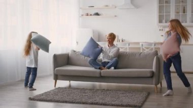 Bir aile, rahat oturma odalarında yastık savaşı yapar. Doğal ışık, ebeveynler ve çocuklar arasındaki neşeli atmosferi yükselterek alanı suyla doldurur..