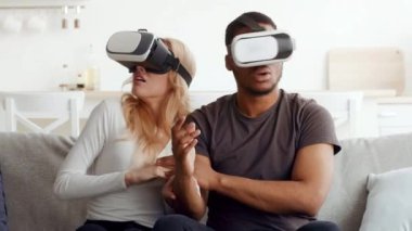Evli bir çift, oturma odalarında sanal gerçeklik kulaklıkları kullanırken heyecan yaşar. Evlerinde bir an eğlenip kaynaşırlar..
