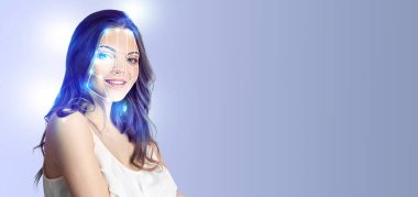 Kendine güvenen bir kadın modern yüz tanıma teknolojisi sergiliyor. Tekniği, onu sakinleştiren, boş bir arkaplan üzerine vurguluyor, yenilikleri vurguluyor..