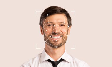 Yüzünde yüz tanıma işaretleri olan gülümseyen bir adam görülüyor. Bu teknoloji kimlik tespiti ve doğrulama için kullanılır. Arkaplan konu üzerinde boş alan arttırıcı odak sağlar.