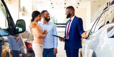 Yakışıklı Siyah Menajer Genç Bir Çifte Araba Gösteriyor, Profesyonel Satış Görevlisi Şov Salonunda Afrikalı Amerikalı Eşlere Lüks Otomobil Gösteriyor, Aile Yeni Araç Seçiyor