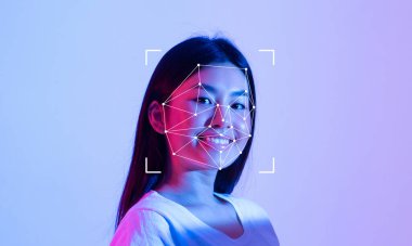 Yüz tanıma teknolojisi yüzünden okunurken genç bir insan gülümsüyor..