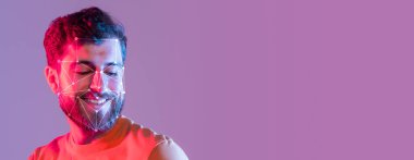 Sakallı bir adam gülümserken yüz tanıma programı anahtar özellikleri ön plana çıkarıyor. Canlı arka plan modern bir dokunuş katıyor, teşhis teknolojisinde gelişmeler gösteriyor..