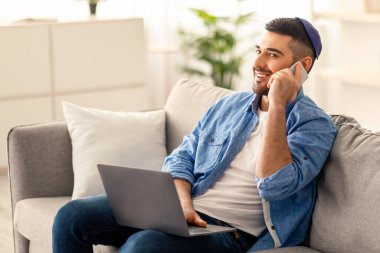 Evden işe gidiyorum. Erkek Yahudi girişimci cep telefonuyla konuşuyor. Ev işyerinde dizüstü bilgisayar kullanıyor, kanepede oturuyor. Ortaklarla tartışma, gelecekteki toplantıları planlama, müşteri danışmanlığı kavramı