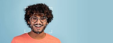 Kıvırcık saçlı ve gözlüklü genç bir insan gülümserken yüz tanıma teknolojisi onların özelliklerini açık mavi arka planda analiz ediyor. Kurulum tanımlama yeteneğini vurguluyor.