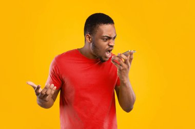 Sinirli siyah adam, sarı arka planda rahatsız edici bir telefon konuşması yaparak cep telefonuna bağırıyor. Stüdyo, telefonda kızgın bir şekilde konuşan adamın görüntüsü. Mobil İletişim Sorunu
