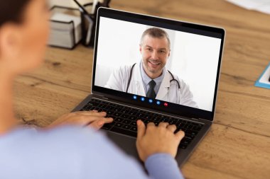 Bir kadının evde otururken doktoruyla görüntülü konuşma yapması. Bilgisayardaki pratisyen hekimle dijital konferansta hastayı kapatıyoruz. Hasta kadın online danışmanlık yapıyor.