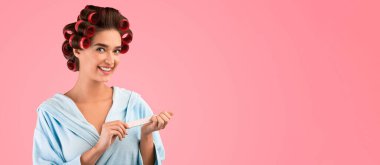 Neşeli Kadın Manikür Yapıyor Tırnak tamponunu kullanarak Tırnaklarını törpülüyor Sarı Stüdyo Arkaplanında Duruyor, Kameraya Gülümsüyor. Kadın Güzellik Programı ve Çivi Bakımı Konsepti