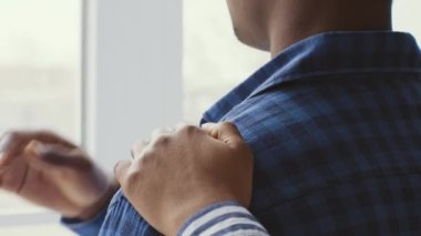 Genç bir çift zor zamanlarında birlikte oturup rahatlık sağlıyor. Partnerlerden biri diğerinin omzuna yaslanır, kendini kötü hissederken destek olur..