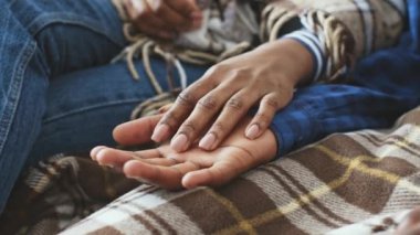 Afro-Amerikalı bir çift, hastalıktan kurtulurken battaniyelere sarılı olarak evde dinleniyor. Soğuk algınlığı veya grip tedavisi süresince destek anlarını paylaşıyorlar.