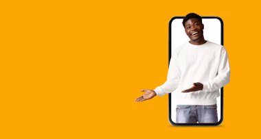 Bir insan büyük ekranlı akıllı telefon kullanarak iletişim kurar. Parlak turuncu arkaplan, modern teknoloji ve sosyal medya uygulamalarını vurgulayarak etkileşimi vurguluyor.