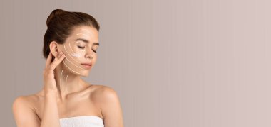 Bir kadın güzellik rutinini yapar, yüzüne cilt bakım ürünleri uygular. Yumuşak, nötr bir arkaplanda izole edilmiş. Kendini şımartmak için sakin ve rahatlatıcı bir atmosfer yaratıyor..