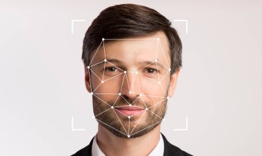 Tarafsız bir ifadeye sahip bir adam düz bir arkaplana karşı duruyor, yüz tanıma teknolojisi sayesinde yüz hatlarını tespit edebiliyor..