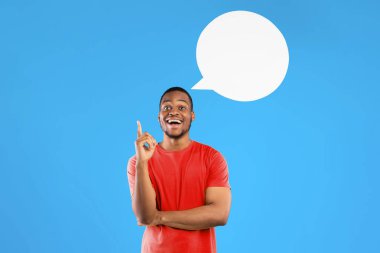 Harika bir fikir. Mavi Stüdyo Arkaplanı 'nın üzerinde duran kameraya gülümseyen boş konuşma baloncuğuyla parmağını havaya kaldıran heyecanlı siyahi adam. Eureka Anı, İlham Konsepti. Kare