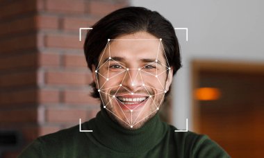 Yüz tanıma teknolojisi özelliklerini tararken bir adam gülümsüyor. Arka plan hafifçe bulanık, neşeli ifadeleri ve yenilikçi teknolojiyi vurgulayan konular.