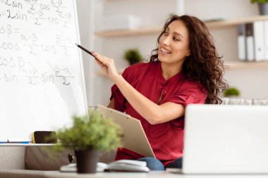 Gülümseyen öğretmen portresi internette sohbet ediyor, dizüstü bilgisayar kullanıyor, özel ders veriyor, Webinar kaydediyor, anlatıyor, öğrencilere öğretiyor. Uzaktan eğitim, evden danışmanlık, tekneyi işaret etmek.