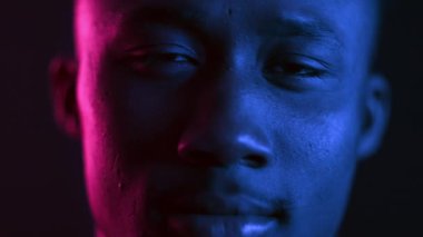 Havalı bir milenyum adamı canlı, neon bir arka plana karşı güvenle ayakta duruyor. İfadesi rahat, geleceğin renkleriyle ve ambiyanslarıyla çevrili bir hipster estetiğini somutlaştırıyor..