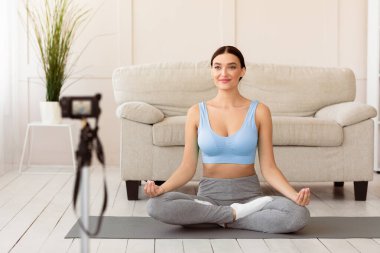 İnternette Meditasyon. Yoga blogcusu Kadın Spor Blog 'u Evde Lotus pozisyonunda oturuyor. Seçici Odaklanma