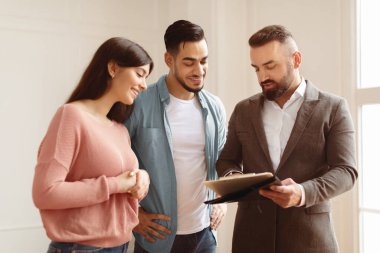 Yeni Ev 'i alıyorum. Gülümseyen genç Arap eşler emlakçı ya da komisyoncuyla anlaşma yapıyor. Profesyonel mali danışman ya da satıcı toplantıda müşterilere sözleşme detaylarını açıklıyor