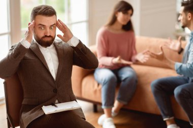 Şok olmuş aile danışmanı genç bir çiftin ofisinde duygusal münakaşa etmelerini, kavga etmelerini ve birbirlerine bağırmalarını dinleyerek başını tutuyor.