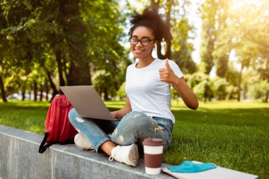 Afrikalı Öğrenci Kız Hareketleri Dizüstü Bilgisayarı Onaylayan Onaylama Programı ya da İnternet Sitesi Başparmaklarını Gösterip Kameraya Gülümsüyor. Üniversite Öğrencisi E-Öğrenmeyi Seviyor