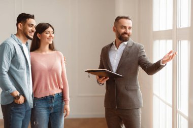 Emlakçı Konsepti ile görüşme. Profesyonel Emlakçı Sahne Görünümünü Yerden Tavana Gösteriyor Pencerelerden Güzel Genç Çiftler Satın Almaya veya Modern Ev 'de Yeni Daire Kiralamaya