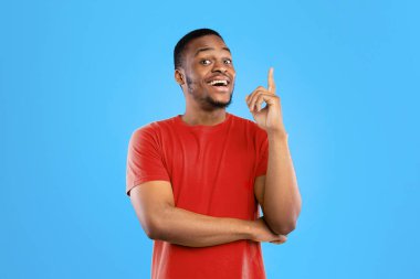 Harika bir fikrim var. Heyecanlı Siyah Milenyum Adamı, Mavi Arkaplanda Gülümseyen Kameraya Gülümseyen Adam. Stüdyo çekimi. İlham ve Eureka Anlık Konsepti, Parlak Reklam Sancağı