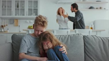 Bir yuva ortamında, ebeveynleri hararetli bir tartışmaya girerken iki çocuk korku ve üzüntü belirtileri gösterir. Çocuklar birbirlerinde huzur ararken ortam gergin..