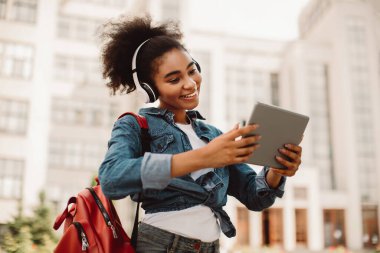 Afro-Amerikalı Kız Öğrenci Videosu Tablet Bilgisayardan Aranıyor Kulaklık takıyor Dışarıdan İletişim Kuruyor. Modern Uzaktan Eğitim ve E-Öğrenme Konsepti