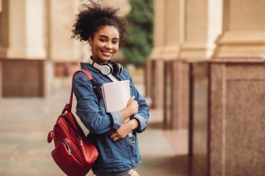 Neşeli Siyahi Öğrenci Kucaklaşma Kitapları Sırt çantasıyla Açık Üniversite Binası 'nın yanında, Kameraya Gülümsüyor. Modern eğitim, kolej harcı ve burslar, yurtdışında öğrenim ve öğrenim