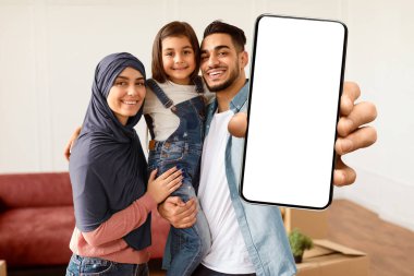 Mutlu Müslüman Aile Anahtarlarını Gösterme, Neşeli Ebeveynler Küçük Çocuğa Sarılma, Kızını Ellerinde Tutma. Yeni Apartman 'a taşınan Araplar Oturma odasında duruyorlar. Seçici Odaklanma