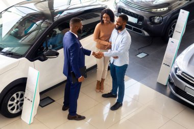 Modern Satış Merkezi 'nde müşteri temsilcileriyle el sıkışan siyah satıcı, başarılı bir anlaşmadan sonra müşterilerle el sıkışırken en iyi oto galerisi müdürü, yeni otomobil satışı...