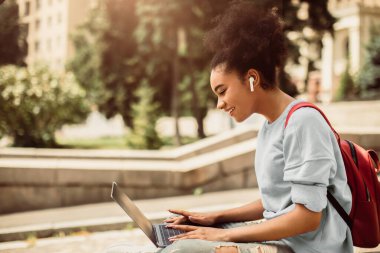 Mesafe öğrenme. Uzaktan kumandalı derslerle internette gezinen Afro-Amerikan Öğrencileriniz kutlu olsun. Bilgisayar kullanan üniversiteli kız. E-Öğrenme, İnsanlar ve Gadget