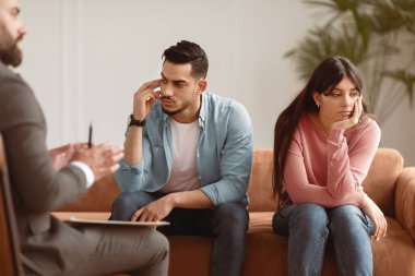 Evlilik Terapisi Konsepti. Depresyondaki Orta Doğulu karı koca birbirlerini görmezden geliyorlar, konuşmuyorlar, üzgün milenyum çifti terapist ofisinde koltukta oturup uzlaşmaya hazır değiller.