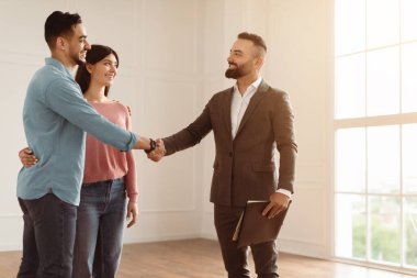 Anlaşma Anlaşması Belirleniyor. Milenyum Çifti 'nin Yeni Bir Daire Alırken Portresi, Profesyonel Emlakçıyla Tokalaşmak. Gülümseyen Takım Elbiseli Müdür Mutlu Genç Aileye Daire Satıyor