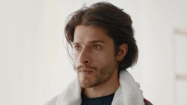 Genç bir beyaz adam, çağdaş bir ev ortamında ağırlık kaldırırken güç eğitimine odaklanır. Egzersiz fitness ve kararlılığı vurguluyor.