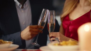 Genç ve değişik bir çift, samimi bir restoranda romantik bir anı paylaşıyor. Lezzetli yemekler ve sıcak mum ışığıyla süslenmiş bir masada otururken şampanya bardaklarını tokuştururlar..