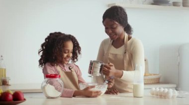 Bir anne ve kızı evde neşeli bir yemek pişirme etkinliğine girişiyor. Kahkahalar ve gülümsemeleri paylaşarak bir kasede malzemeleri karıştırıyorlar. Mutfakta güzel anılar yaratıyorlar..