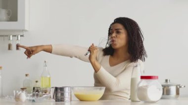 Sıcak bir mutfakta neşeli bir Afrikalı Amerikalı kadın neşe içinde yemek pişiriyor. Malzemeleri karıştırıyor ve evde pişirmenin mutluluğunu somutlaştırarak şarkı söylüyor. Mekan mutfak malzemeleriyle dolu..