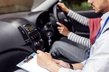 Direksiyondaki direksiyondaki tesettürlü kadından ehliyet sınavı alan genç, ciddi Müslüman öğretmen. Kesildi. Akıl hocası öğrencilere araba sürmeyi, sürücü kursunu ve iyi notları öğretiyor. Eğitim ve öğrenim