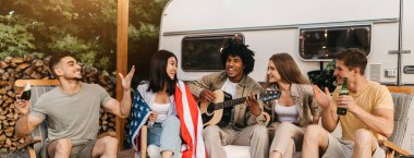Neşeli ırklar arası arkadaşlar gitar çalıyor, şarkı söylüyorlar, Amerikan bayrağı tutuyorlar, bira içiyorlar, karavanın yanında oturuyorlar, Bağımsızlık Günü 'nü kutluyorlar, yaz tatilinde kamp yapıyorlar.