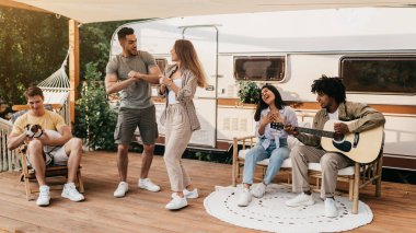 Şirin köpekli çeşitli arkadaşlar karavanın yanında eğleniyor gitar çalıyor, şarkı söylüyor, dans ediyor, yaz tatilinin tadını çıkarıyor, hafta sonları dışarıda dinleniyor.