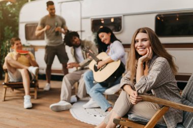 Bir grup mutlu genç kamp gezisinde eğleniyor, şezlonglarda oturuyor, gitar çalıyor, bira içiyor, karpuz yiyor, kırsalda serin yaz tatilinin tadını çıkarıyor, uzay fotokopisini çekiyor.