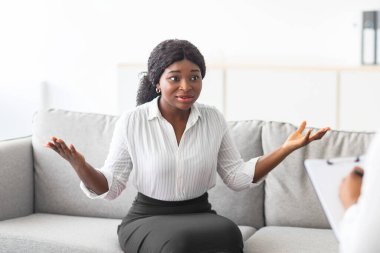 Genç Afro kadının psikologla randevusu var. Ofiste koltukta oturup danışmana sorununu anlatıyor. Klinikteki psikoterapistle iletişim kuran bin yıllık siyahi kadın.